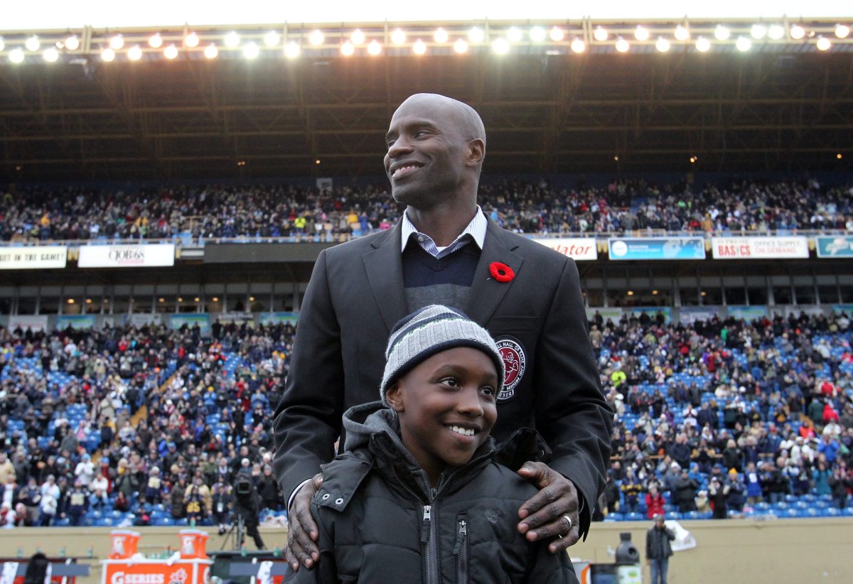 Milt Stegall with his son, Chase, during a ceremony for the hall of fame inductees at half-time in CFL action between the Winnipeg Blue Bombers and the Montreal Alouettes in Winnipeg Saturday, November 3, 2012. (CFL PHOTO - Marianne Helm).