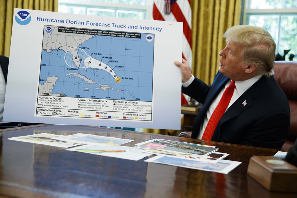 U.S. President Donald Trump holds a chart as he talks with reporters after receiving a briefing on hurricane Dorian in the Oval Office of the White House, Wednesday, Sept. 4, 2019, in Washington, D.C.