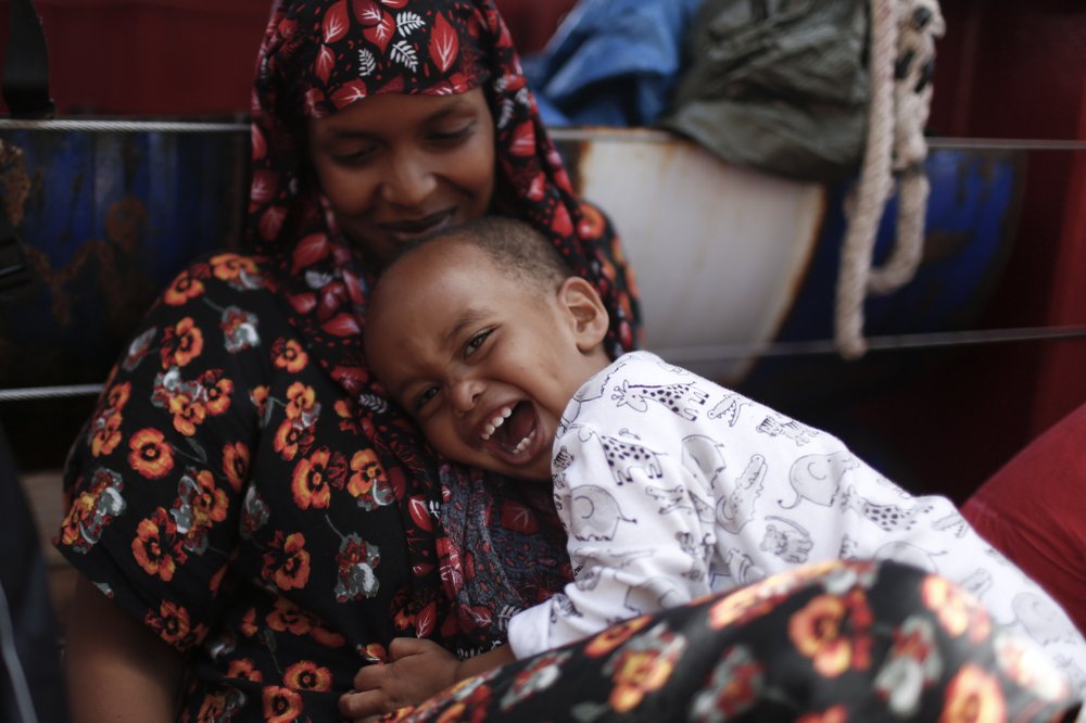 One-year-old child Mascuud, from Somalia, smiles as he hugs his mother aboard the Ocean Viking humanitarian rescue ship, in the Mediterranean Sea, Thursday, Sept. 13, 2019. Eighty-two rescued migrants remain on board the humanitarian rescue ship waiting for a European country to give them permission to disembark. 