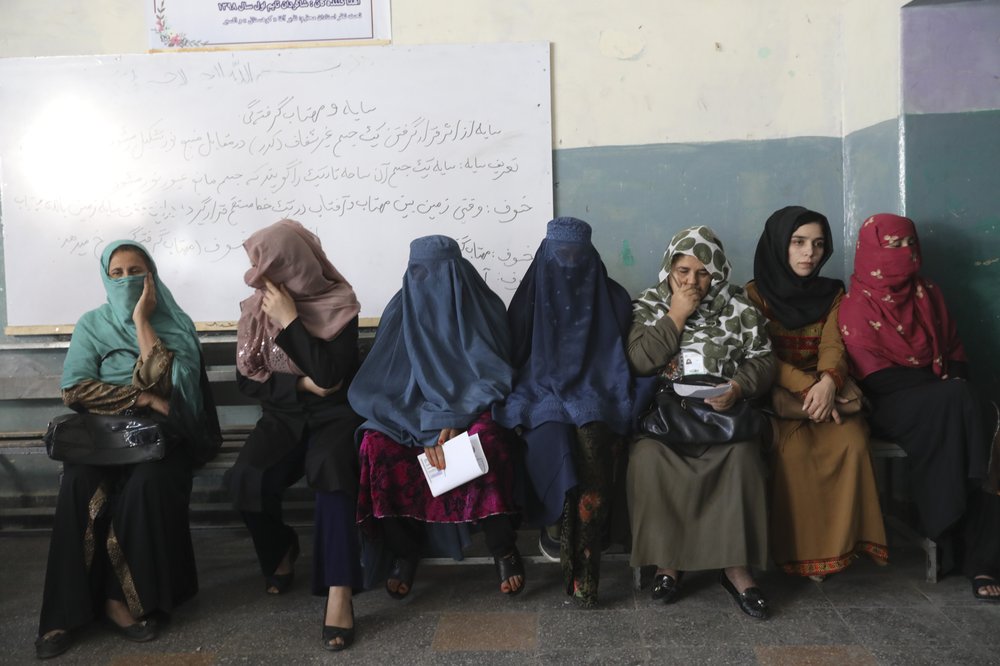 Afghan women wait for the a polling station to open in Kabul, Afghanistan, Saturday, Sept. 28, 2019. Afghans headed to the polls on Saturday to elect a new president amid high security and Taliban threats to disrupt the elections, with the rebels warning citizens to stay home or risk being hurt. 