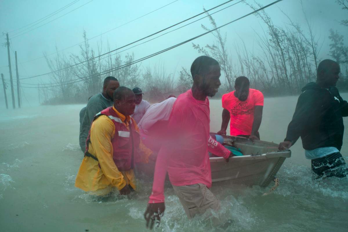 Volunteers rescue several families from the rising waters of hurricane Dorian, near the Causarina bridge in Freeport, Grand Bahama, Bahamas, Tuesday, Sept. 3, 2019. (AP Photo/Ramon Espinosa)