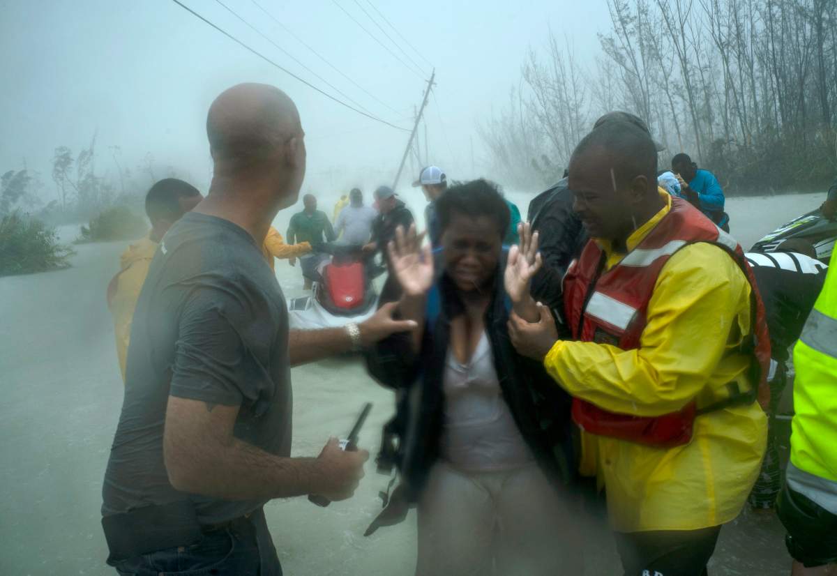 Volunteers rescue several families that arrived on small boats from the rising waters near the Causarina bridge in Grand Bahama on Sept. 3, 2019. (AP Photo/Ramon Espinosa)