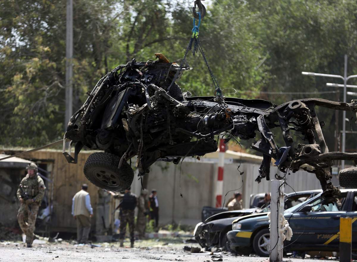 Resolute Support (RS) forces remove a destroyed vehicle after a car bomb explosion in Kabul, Afghanistan, Thursday, Sept. 5, 2019. The Afghan government says at least 10 civilians are dead and another 42 wounded after a Taliban suicide car bombing rocked the Afghan capital near a neighborhood housing the U.S. Embassy and the NATO Resolute Support mission.