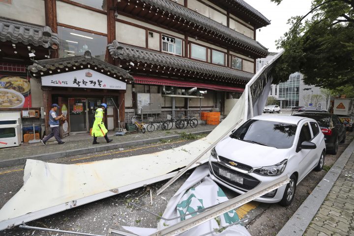 A vehicle is damaged by fallen signboard from a building as Typhoon Lingling brings strong wind and rain in Seoul, South Korea, Saturday, Sept. 7, 2019. The typhoon passed along South Korea's coast Saturday, toppling trees, grounding planes and causing at least two deaths before the storm system made landfall in North Korea. 