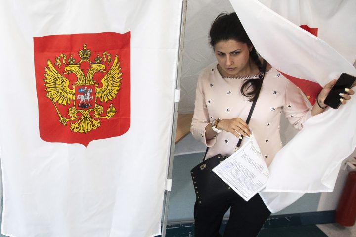 A woman exits a polling booth before casting at a polling station during a city council election in Moscow, Russia, Sept. 8, 2019. 