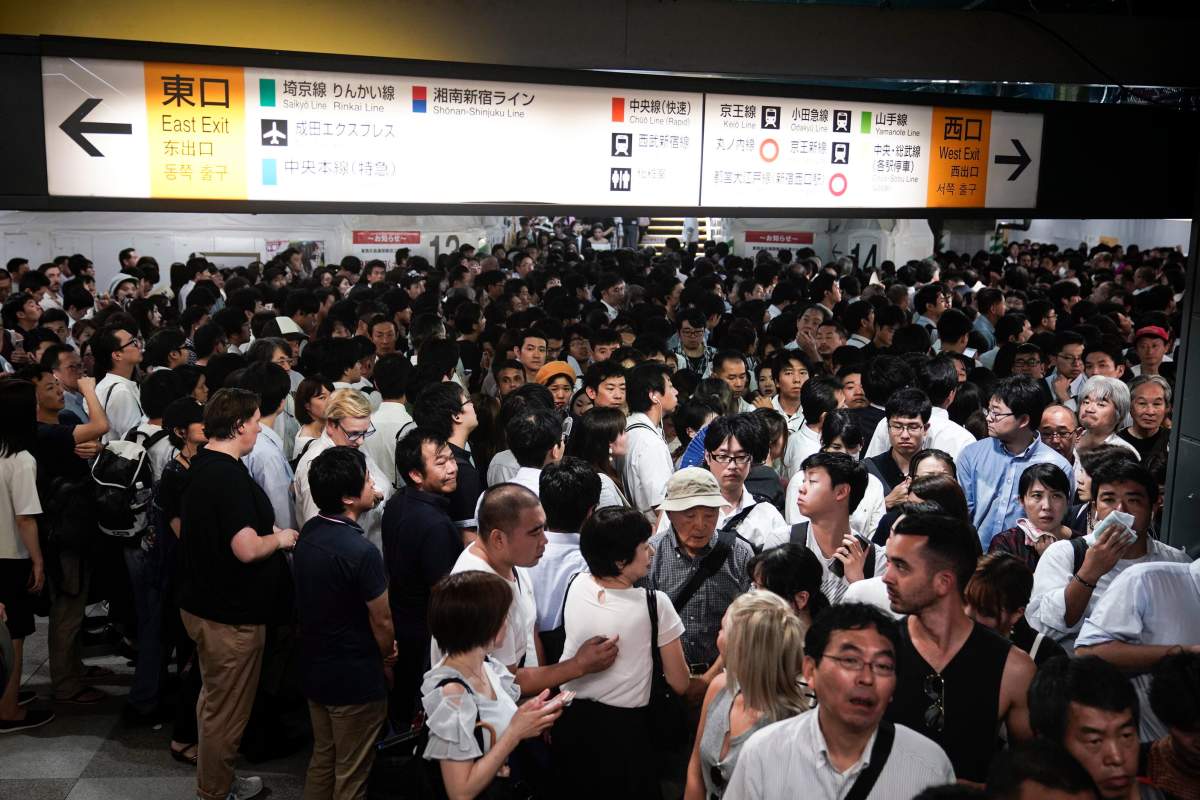 Commuters wait for train platforms to open at Shinjuku Station, following some suspension of train services caused by a typhoon passing through the area in Tokyo on Monday, Sept. 9, 2019.