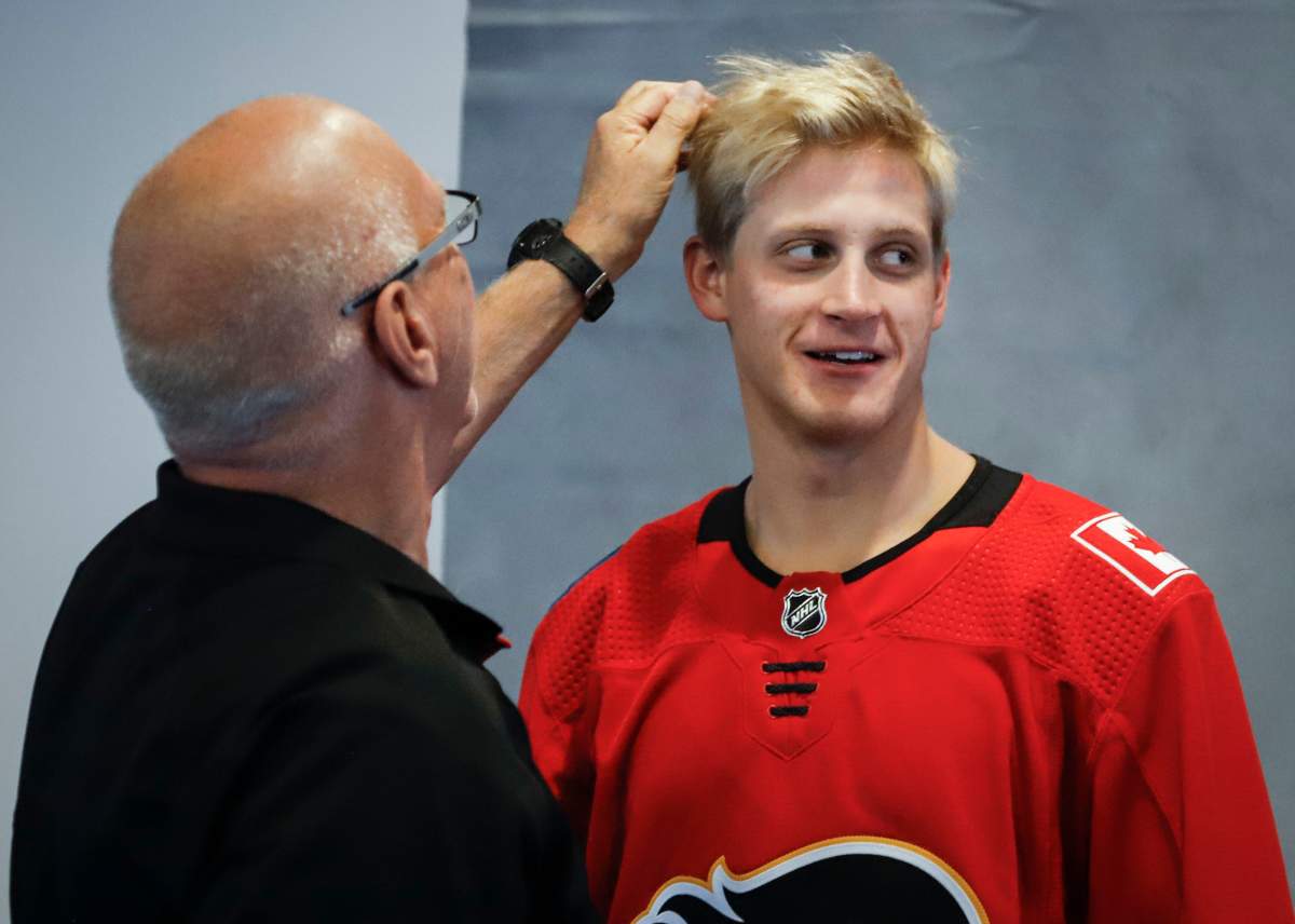 Calgary Flames’ Juuso Valimaki has his hair adjusted by photographer Brad Watson at the Flames main camp testing day in Calgary, Thursday, Sept. 12, 2019.