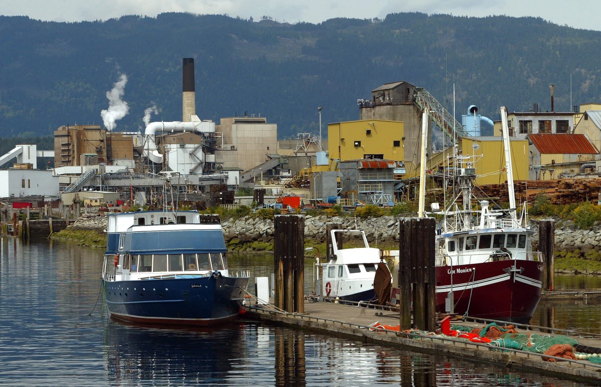Commercial fishing boats in the foreground and the NorskeCanada paper mill in the background at Port Alberni on Vancouver Island, British Columbia.                