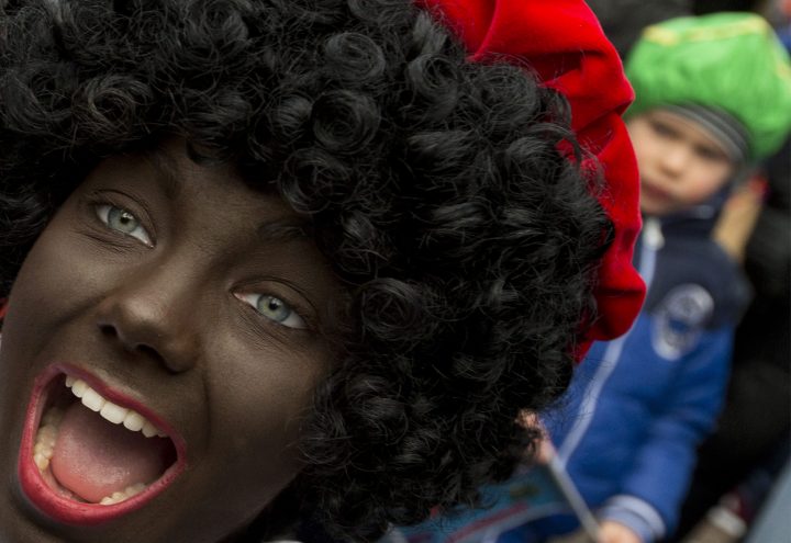 A Black Pete interacts with children during the arrival of Sinterklaas, or Saint Nicholas, in Maassluis, Netherlands, Saturday, Nov. 12, 2016.