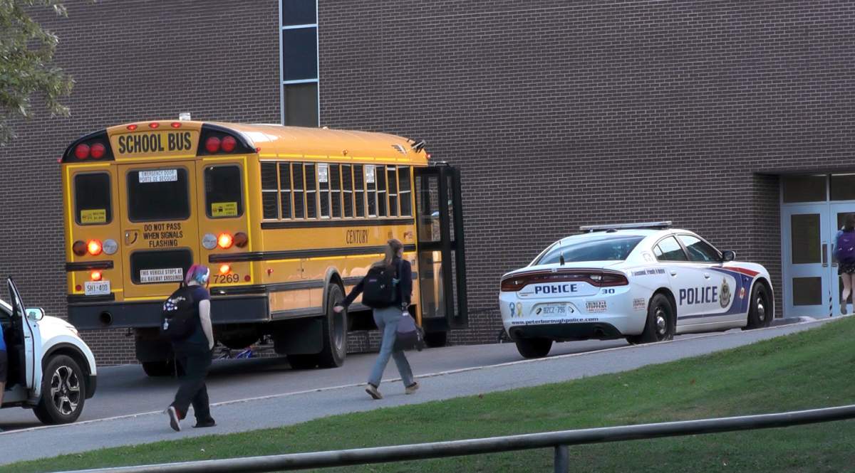 A police cruiser sits outside Adam Scott Collegiate Vocational Institute on Friday.