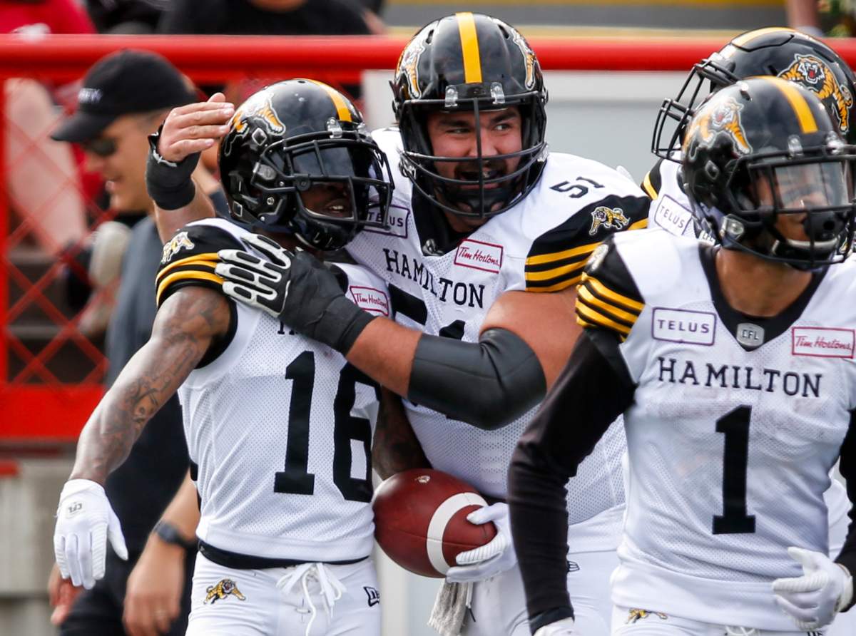 The Hamilton Tiger-Cats became the first team in the CFL this season to clinch a playoff spot after beating the Edmonton Eskimos 30-27 Friday night.