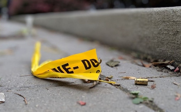 A shell casing is seen next to police tape.