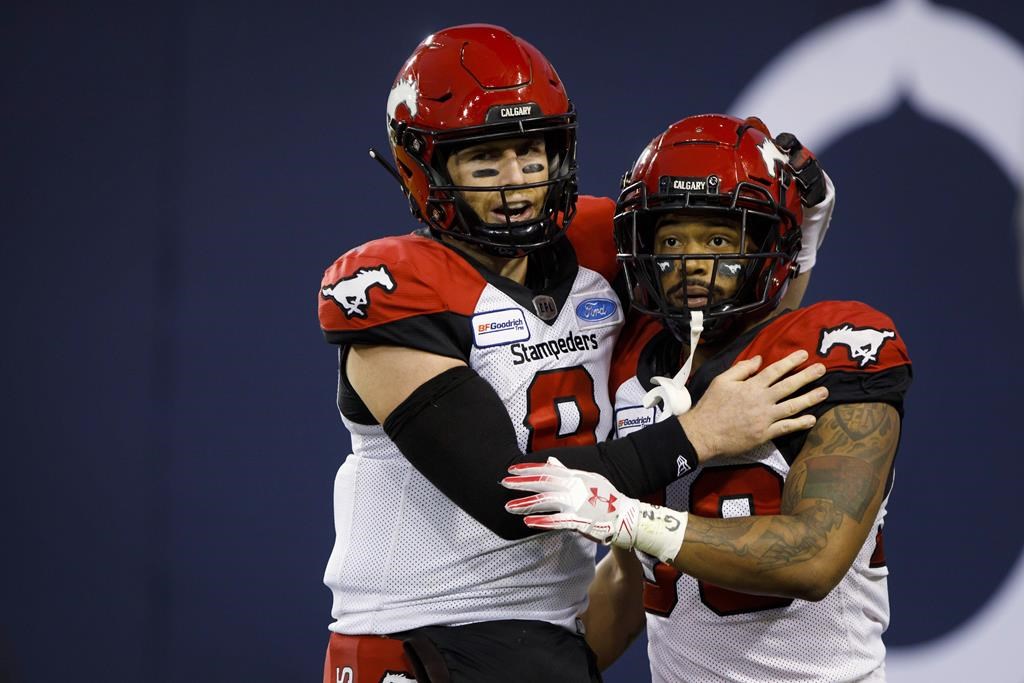 Calgary Stampeders defensive back DaShaun Amos (8) celebrates a touchdown with Calgary Stampeders running back Terry Williams (38) during first half of CFL action against the Toronto Argonauts in Toronto, Friday, Sept. 20, 2019.