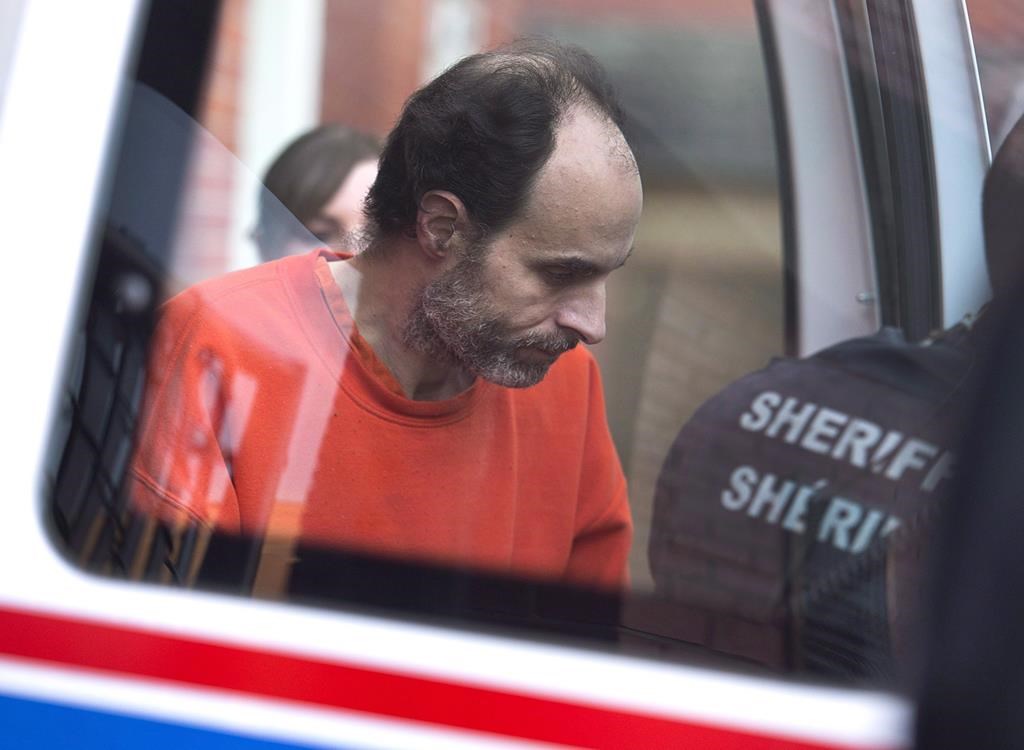 Matthew Vincent Raymond, charged with four counts of first degree murder, is taken from provincial court in Fredericton, N.B., on December 11, 2018.