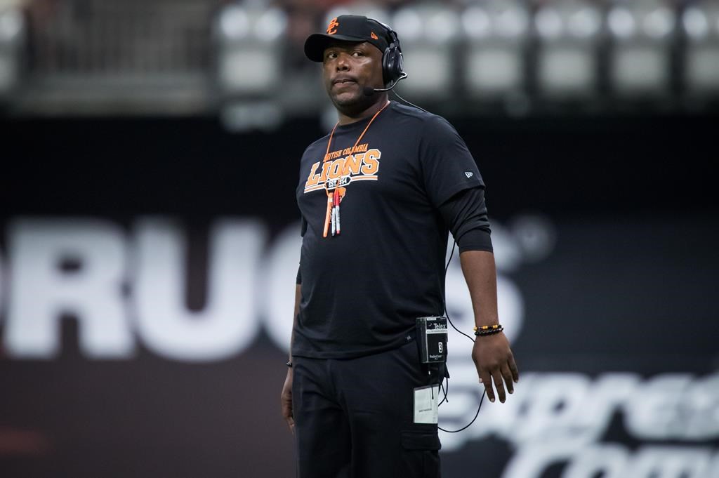 B.C. Lions head coach DeVone Claybrooks stands on the field during a stoppage in play during second-half CFL football action against the Edmonton Eskimos in Vancouver on July 11, 2019.