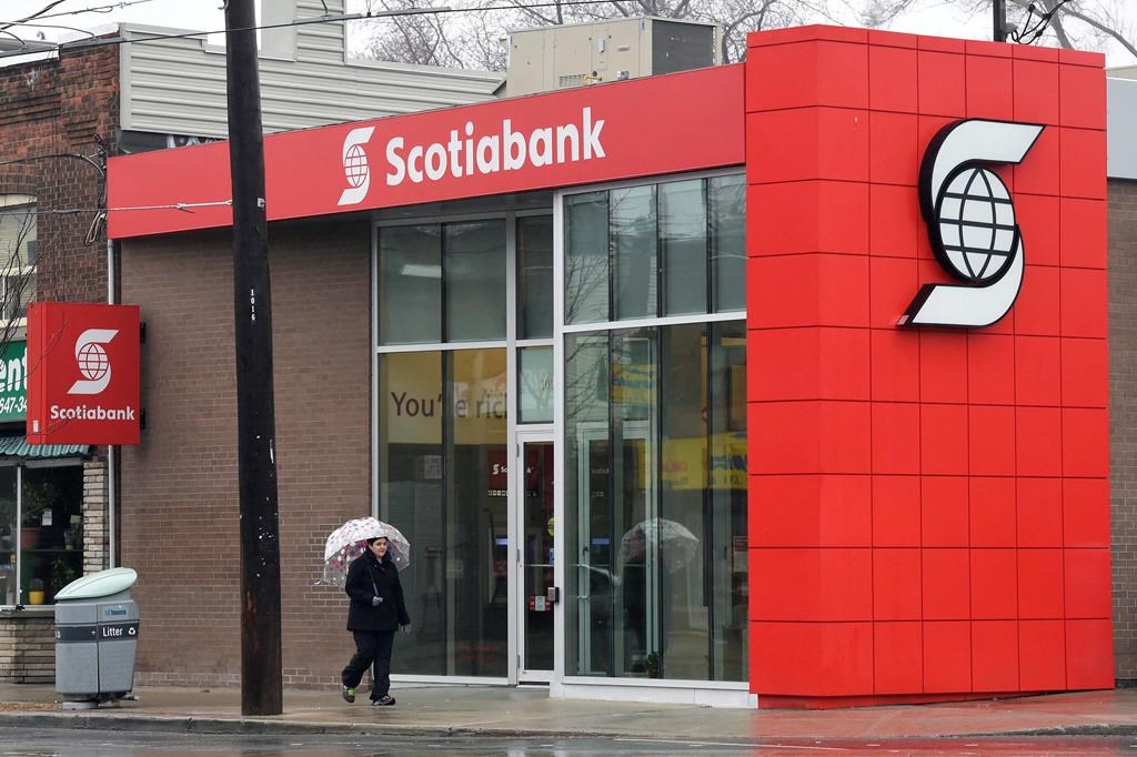A woman walks by a Scotiabank branch in Toronto on Thursday, April 9, 2015.