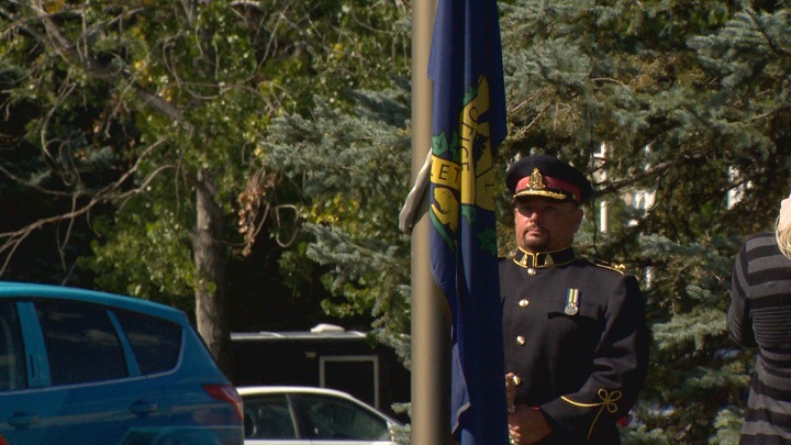 Chief Davis lowers the flag on his last day of service in the Lethbridge community.
