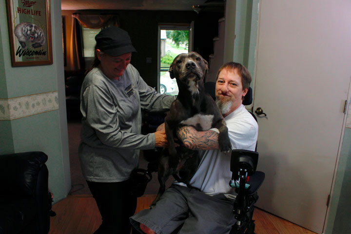 In this Aug. 16, 2019 photo, Greg Manteufel takes his dog Ellie from his wife Dawn Manteufel at their home in West Bend, Wis.