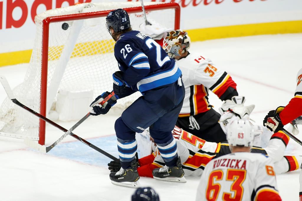 Winnipeg Jets' Blake Wheeler (26) scores on Calgary Flames goaltender Cam Talbot (39) during third period NHL pre-season action in Winnipeg on Sunday, Sept. 22, 2019. THE CANADIAN PRESS/Fred Greenslade.