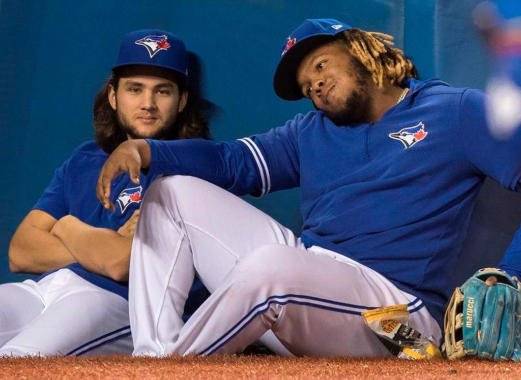 Toronto Blue Jays Vladimir Guerrero Jr. (right) and Bo Bichette sit this one out at edge of dugout in eighth inning of their baseball game against the Tampa Bay Rays in on Sept. 28, 2019.