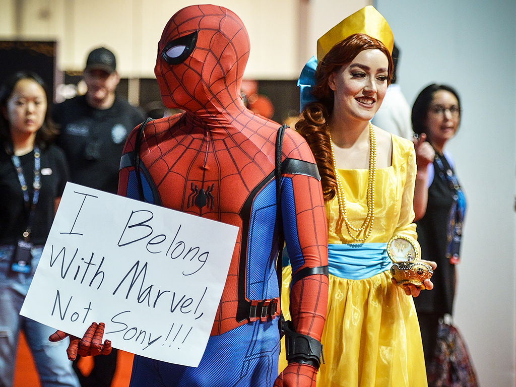 Dane Collaro, dressed as Spider-Man, shows his displeasure with the Sony/Disney spat over the web slinger, as he walks through the D23 Expo with his girlfriend Lauren Wood, dressed as Anastasia, in Anaheim, Calif., on Friday, Aug 23, 2019.