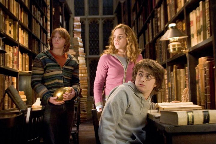 In this photo provided by Warner Bros., Ron Weasley (Rupert Grint), Hermione Granger (Emma Watson) and Harry Potter (Daniel Radcliffe) try to find out about the mysterious event that’s supposed to take place at Hogwarts in ‘Harry Potter and the Goblet of Fire.’