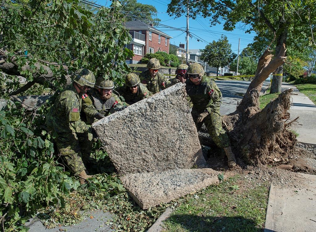 Members of the 4 Engineer Support Regiment from Canadian Forces Base Gagetown move a slab of sidewalk as they assist in the cleanup in Halifax on Monday, Sept. 9, 2019.