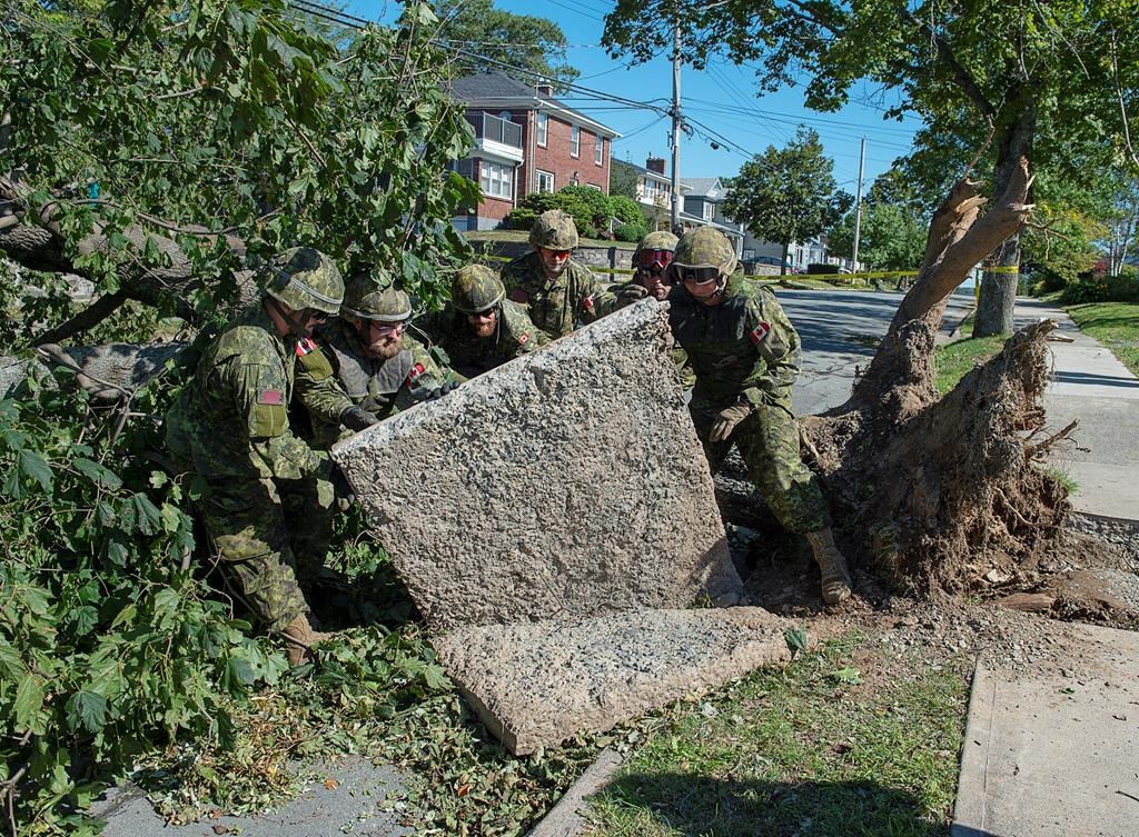 Members of the 4 Engineer Support Regiment from Canadian Forces Base Gagetown move a slab of sidewalk as they assist in the cleanup in Halifax on Monday, Sept. 9, 2019.