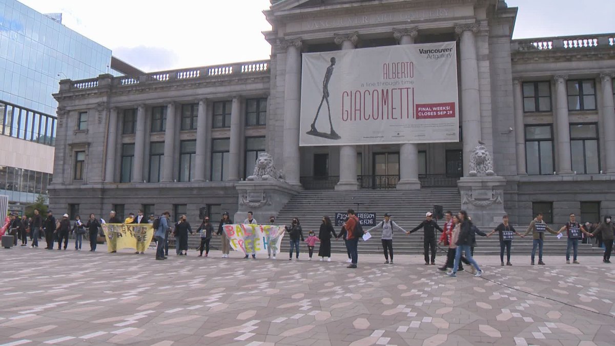 Pro-democracy demonstrators form a human chain outside the Vancouver Art Gallery on Saturday. 