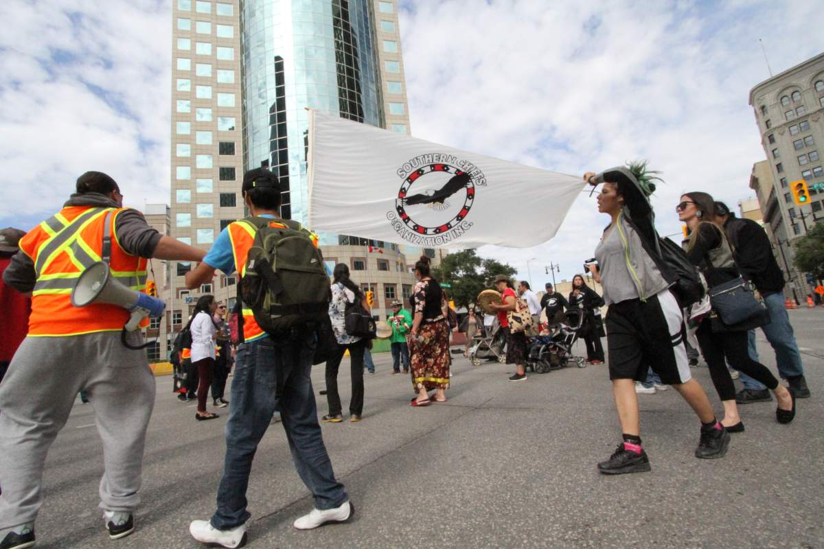 Demonstrators hold a round dance at the corner of Portage and Main.