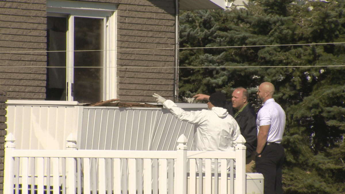 Investigators shown in the backyard of the home Tuesday