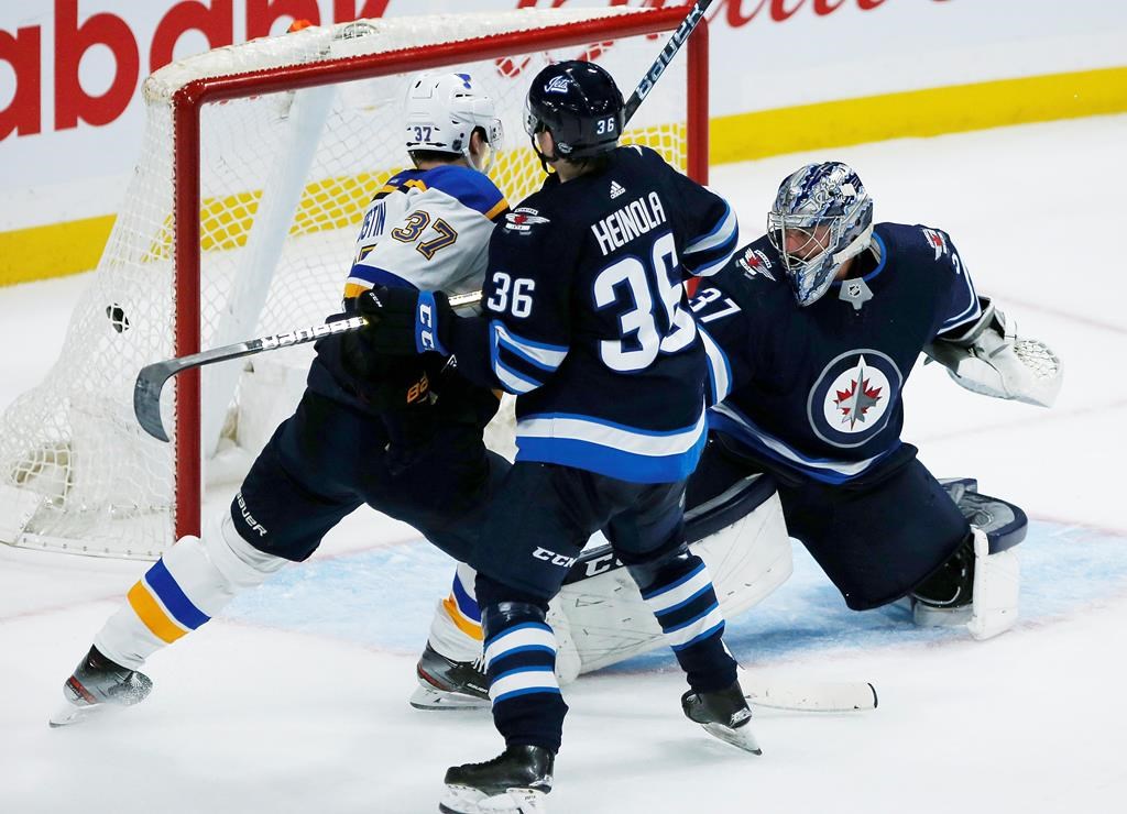 St. Louis Blues Klim Kostin (37) looks on as a shot from teammate David Perron (not shown) beats Winnipeg Jets goaltender Connor Hellebuyck (37) as Ville Heinola (36) defends to win in overtime NHL action in Winnipeg on Friday, September 20, 2019. THE CANADIAN PRESS/John Woods