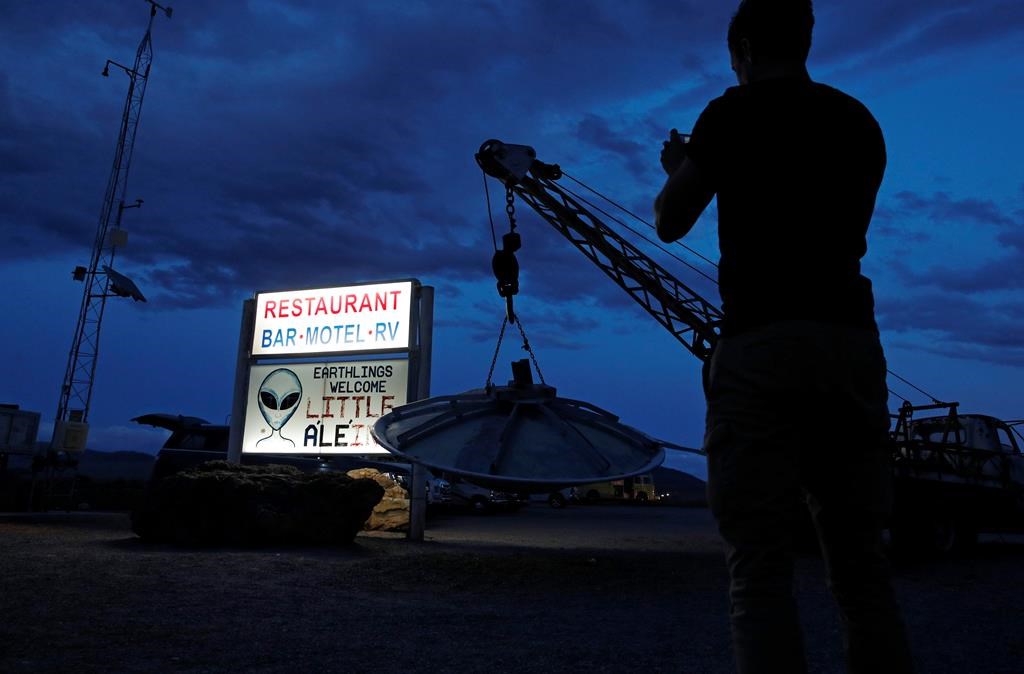 A man takes a picture of a sign at the Little A'Le'Inn during an event inspired by the "Storm Area 51" internet hoax, Thursday, Sept. 19, 2019, in Rachel, Nev.