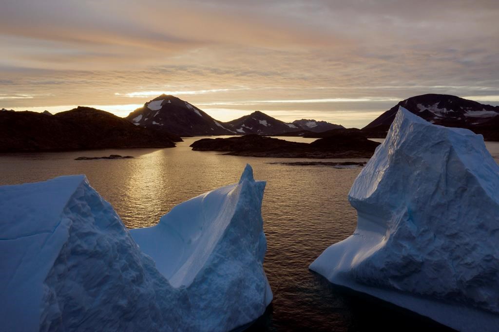 This early Friday, Aug. 16, 2019 file photo shows an aerial view of large Icebergs floating as the sun rises near Kulusuk, Greenland. Greenland has been melting faster in the last decade, and this summer, it has seen two of the biggest melts on record since 2012. A special United Nations-affiliated oceans and ice report released on Wednesday, Sept. 24, 2019 projects three feet of rising seas by the end of the century, much fewer fish, weakening ocean currents, even less snow and ice, and nastier hurricanes, caused by climate change.