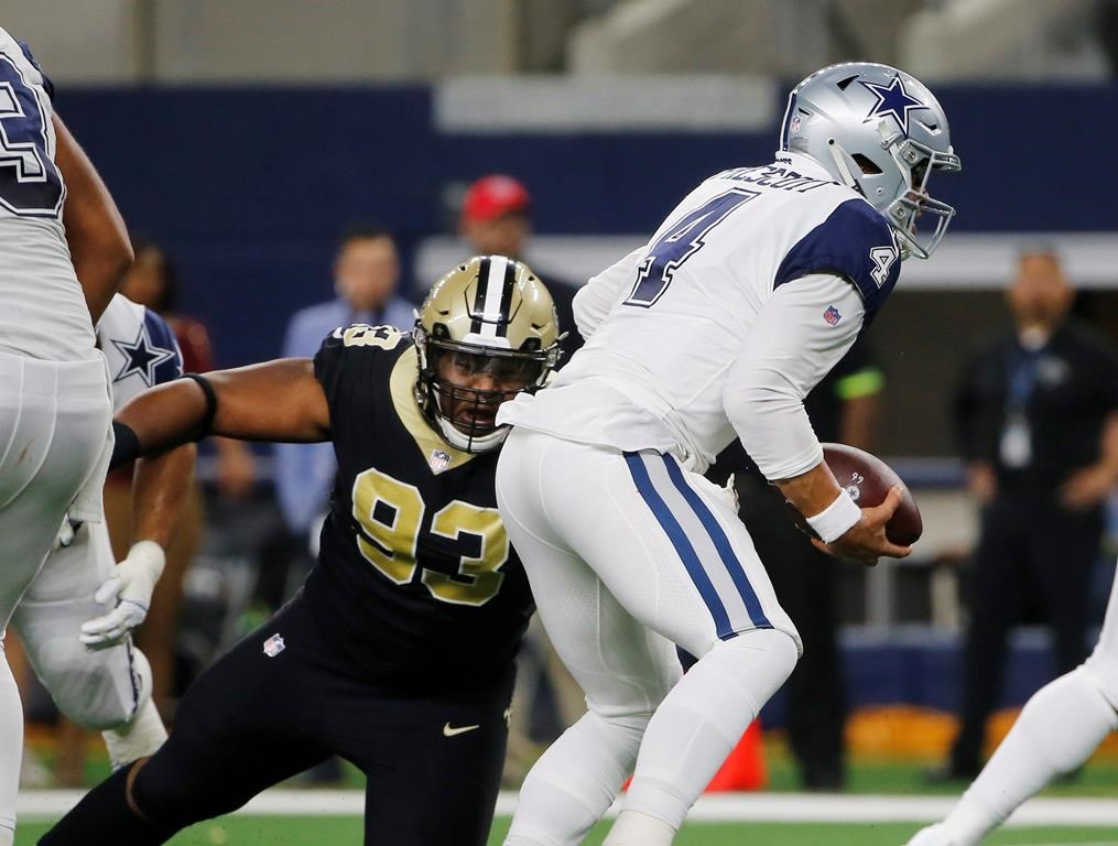In this Nov. 29, 2018, file photo, Dallas Cowboys quarterback Dak Prescott (4) is pressured by New Orleans Saints defensive tackle David Onyemata (93) in the first half of an NFL football game, in Arlington, Texas.