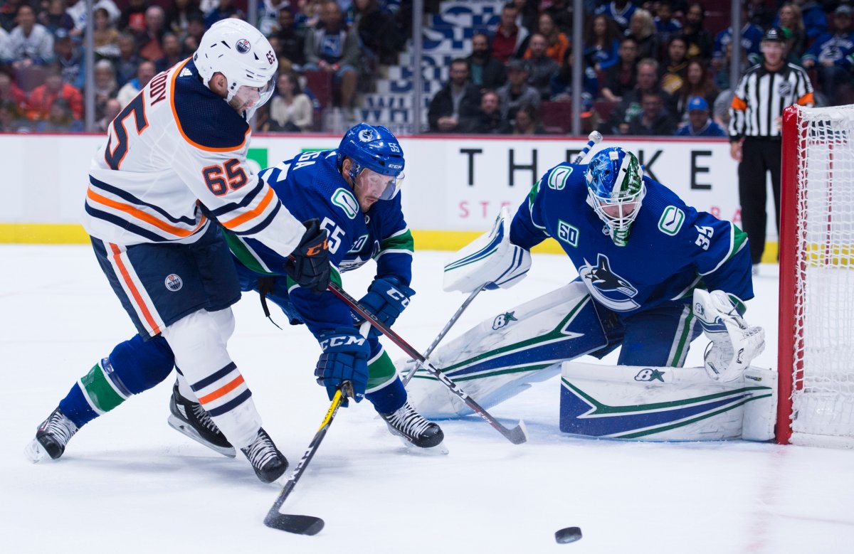 Vancouver Canucks defenceman Alex Biega (55) stops Edmonton Oilers centre Cooper Marody (65) from getting a shot on goaltender Thatcher Demko (35) during first period NHL preseason action in Vancouver, Tuesday, September, 17, 2019. 