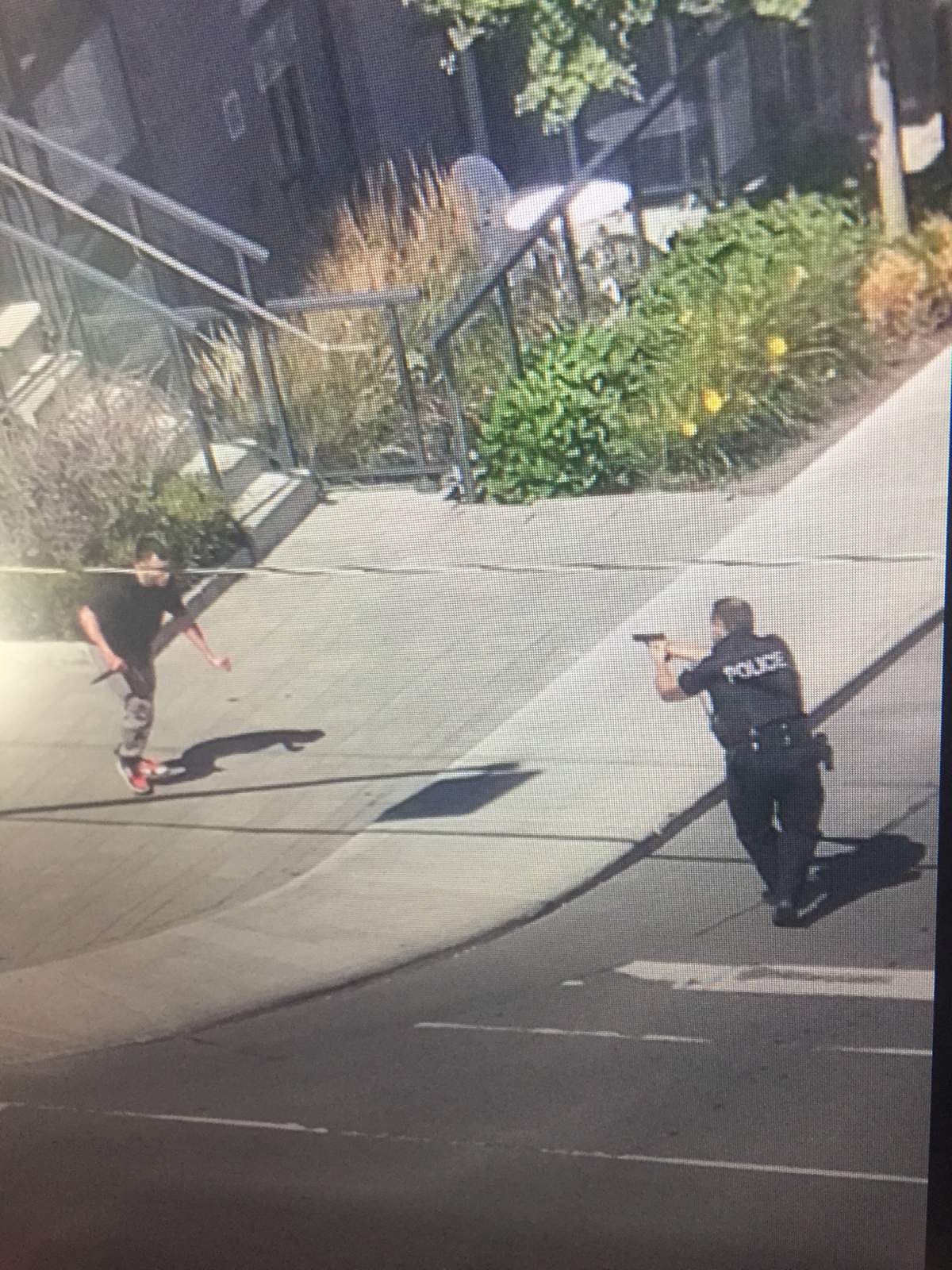 A resident who was in a building nearby says they caught the shooting on camera. The photo shows a police officer pointing a gun at a man with a knife.