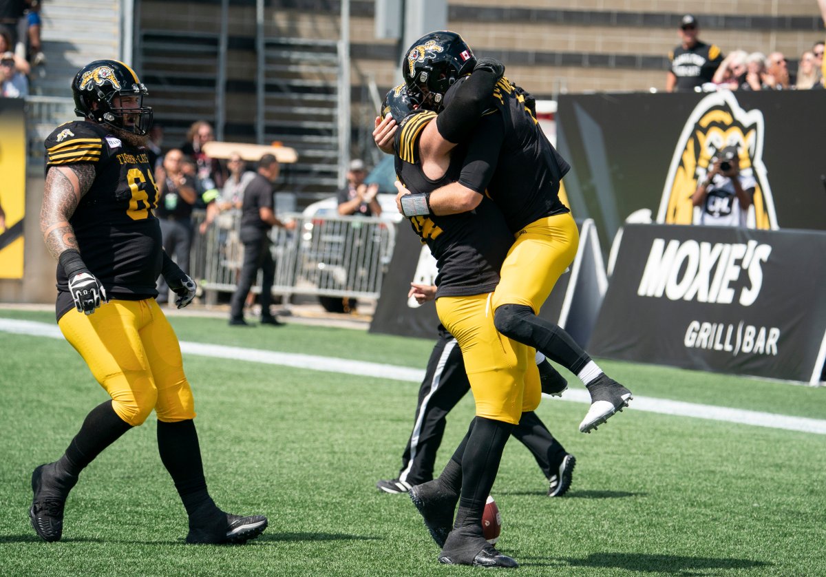 Hamilton Tiger-Cats quarterback Dane Evans (9) celebrates his running touchdown with teammates during first half CFL football game action against the Toronto Argonauts in Hamilton, Ont. on Monday, Sept. 2, 2019. 