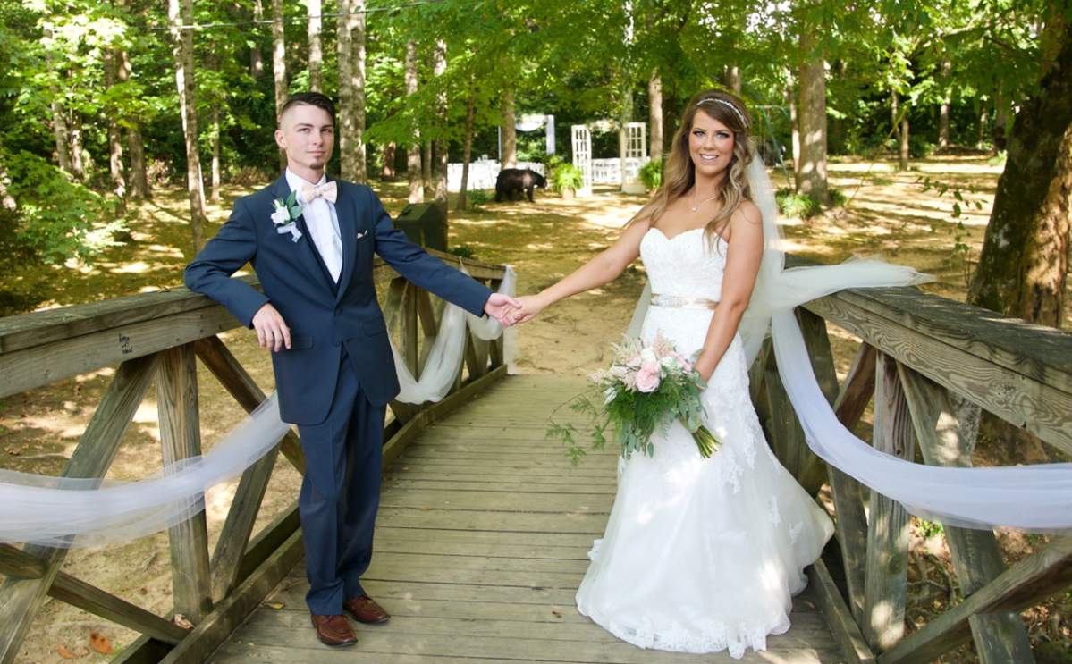 The couple posed for photos before realizing a bear was in the background.