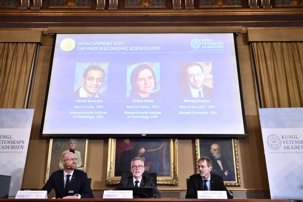 Goran K Hansson, Secretary General of the Royal Swedish Academy of Sciences, center, and academy members Peter Fredriksson, left, and Jakob Svensson announce the winners of the 2019 Nobel Prize in Economics during a news conference at the Royal Swedish Academy of Sciences in Stockholm, Sweden, Monday Oct. 14, 2019. The Nobel prize in economics has been awarded to Abhijit Banerjee, Esther Duflo and Michael Kremer "for their experimental approach to alleviating global poverty." .