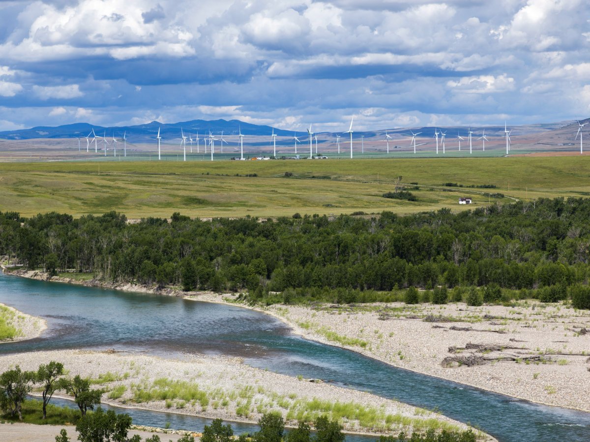 Scenic view of stream with wind turbines in background on rural landscape, Southern Alberta, Alberta, Canada, on Saturday, July 9, 2016. 