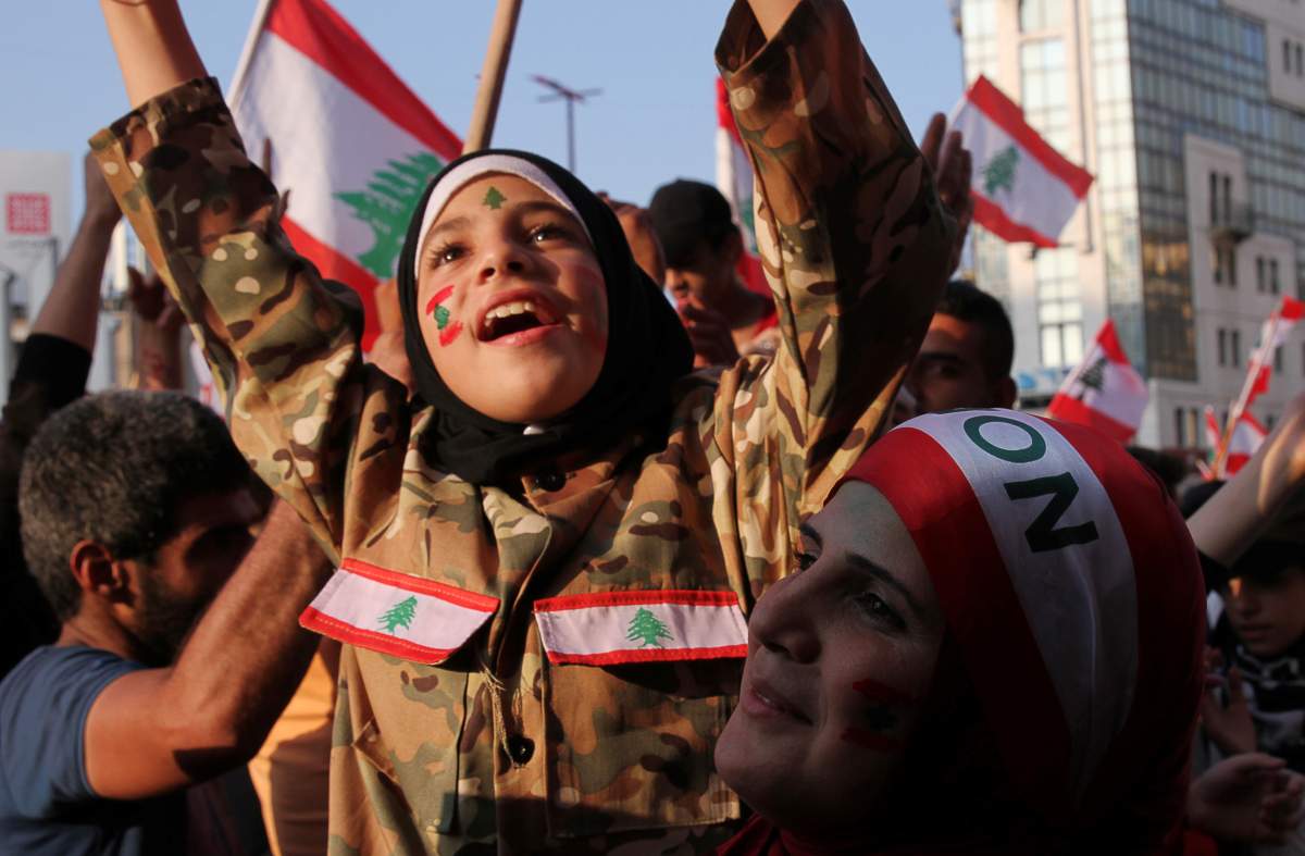 A girl with her face painted with the colors of the Lebanese flag gestures during an anti-government protest in Tripoli, Lebanon October 21, 2019. REUTERS/Omar Ibrahim