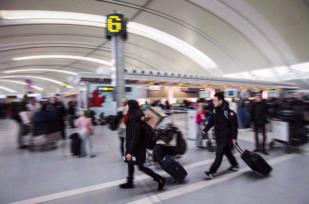 People carry luggage at Pearson International Airport in Toronto on Dec. 20, 2013. 