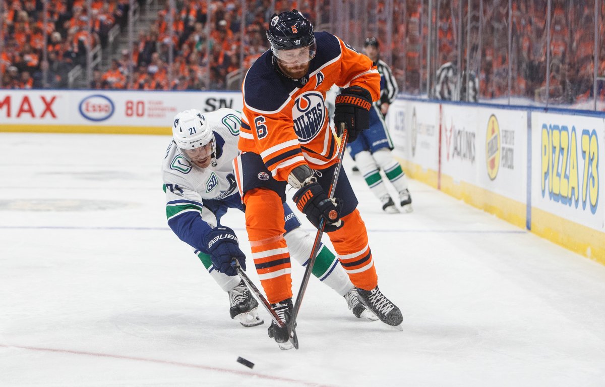 Vancouver Canucks' Loui Eriksson (21) tries to stop Edmonton Oilers' Adam Larsson (6) during first period NHL action in Edmonton, Wednesday, Oct. 2, 2019. 