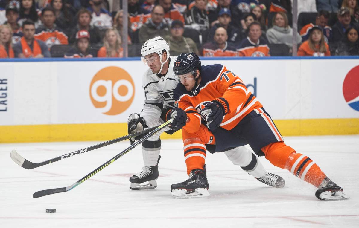 Los Angeles Kings' Sean Walker (26) and Edmonton Oilers' Oscar Klefbom (77) battle for the puck during first period NHL hockey action in Edmonton, Saturday, Oct. 5, 2019. THE CANADIAN PRESS/Jason Franson.