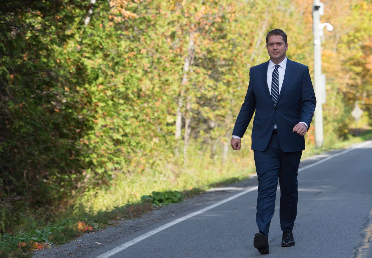 Conservative leader Andrew Scheer walks down Roxham road to make his morning announcement at the Canada/USA border during a campaign stop in Lacolle, Que., on Oct. 9.