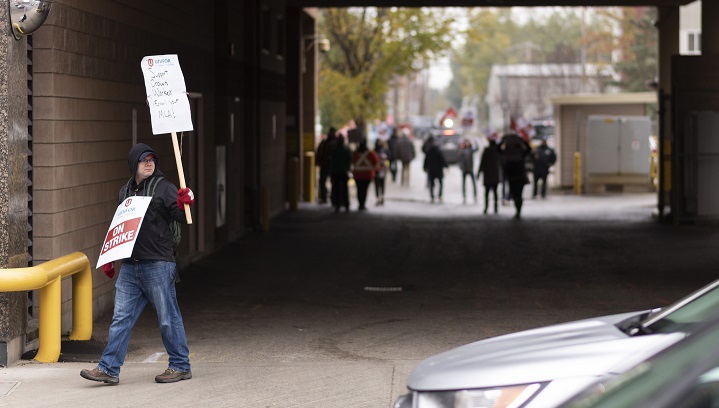 SaskWater employee Brent Stephansson, left, walks a picket line near the SaskEnergy building on Broad St. in downtown Regina Oct. 4, 2019.