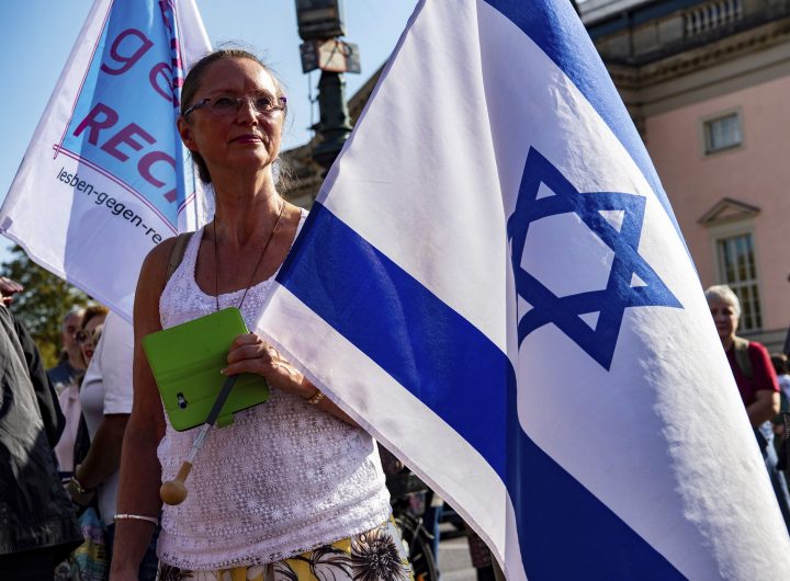A woman with an Israel flag protests with thousands of people on Sunday, Oct. 13, 2019 in Berlin, Germany, against rising anti-Semitism, days after a man attacked a synagogue in the eastern German city of Halle. More than six thousand participated in the march through the German capital on Sunday.