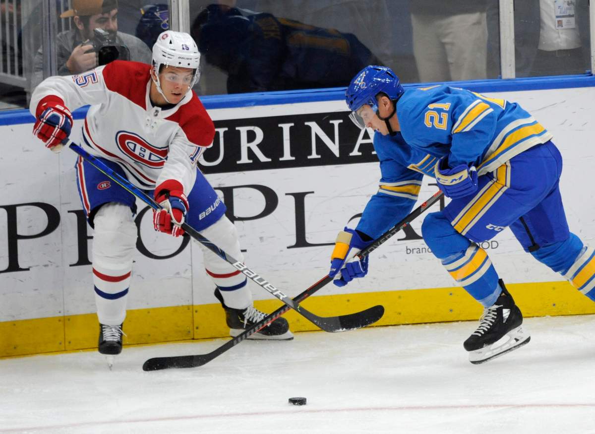 Montreal Canadiens' Jesperi Kotkaniemi (15), of Finland, reaches for the puck with St. Louis Blues' Tyler Bozak (21) during the period of an NHL hockey game, Saturday, Oct. 19, 2019, in St. Louis. 