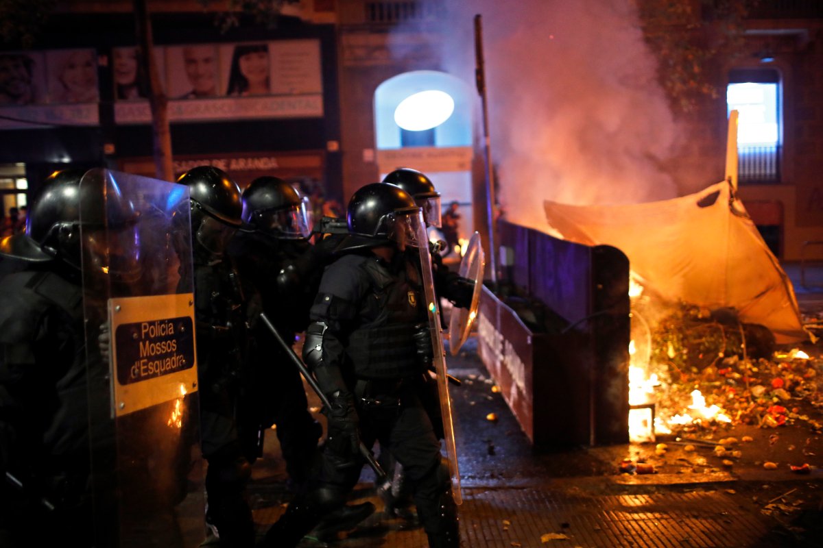 Police in riot gear approach a burning barricade in Barcelona, Spain, Saturday, Oct. 19, 2019. 